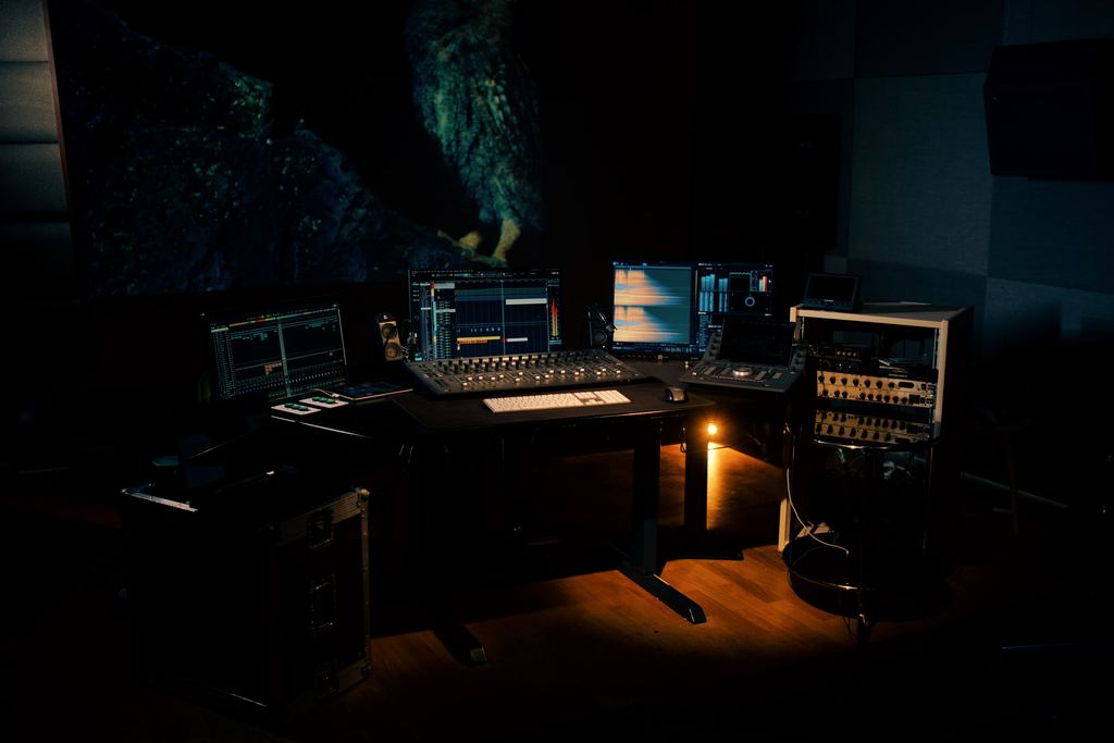 Mixing desk at Sunrise Film with monitors and a projection screen.