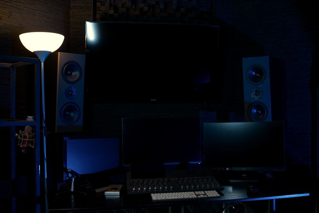 A second Sunrise Film room in blue light with speakers and a desk.